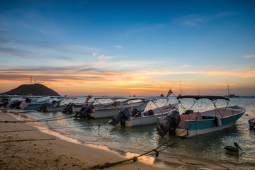Fototapeta na wymiar Boats on the shoreline of a Beach at Los Roques during the Sunset, Beautiful Venezuela