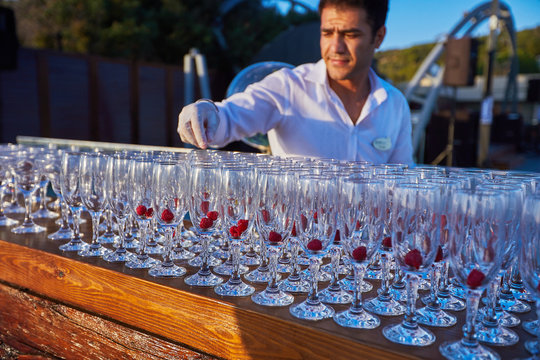 Cocktails with raspberry served on reseption by barmen