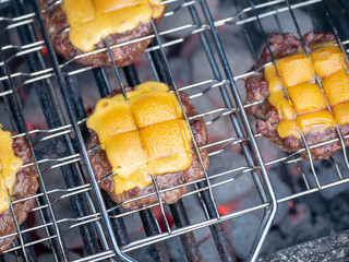 Image of bbq burger patties with cheese on grill