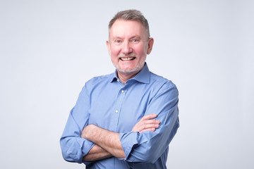 Senior man in blue shirt smiling broadly