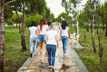 Group of friends women walking in park