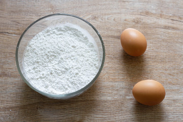 eggs and flour on wooden table