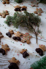 Gingerbread cookies on white board and pain tree branches.
