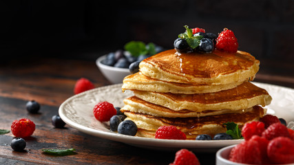 Homemade american pancakes with fresh blueberry, raspberries and honey. Healthy morning breakfast. rustic style - obrazy, fototapety, plakaty
