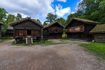 Fototapeta na wymiar Log houses in the farmstead from at Norsk Folkemuseum, one of the most visited museums in Oslo, Norway