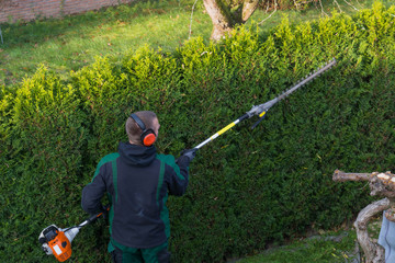 Gardener cuts a hedge