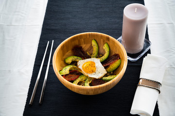 Main dish of egg, avocado and dry tomato and a bowl of yogurt, mango, chestnuts and coffee powder