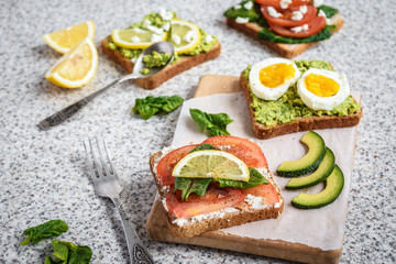Healthy avocado and egg toasts. Toast, avocado, egg, tomatoes, spinach, cheese Feta, lemon. Organic healthy food. Clean healthy eating