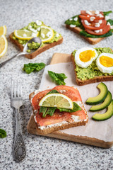 Healthy avocado and egg toasts. Toast, avocado, egg, tomatoes, spinach, cheese Feta, lemon. Organic healthy food. Clean healthy eating