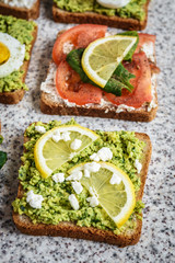 Healthy avocado and egg toasts. Toast, avocado, egg, tomatoes, spinach, cheese Feta, lemon. Organic healthy food. Clean healthy eating