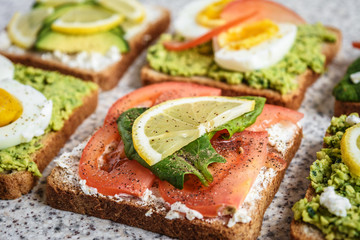 Healthy avocado and egg toasts. Toast, avocado, egg, tomatoes, spinach, cheese Feta, lemon. Organic healthy food. Clean healthy eating