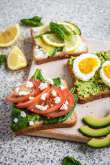 Healthy avocado and egg toasts. Toast, avocado, egg, tomatoes, spinach, cheese Feta, lemon. Organic healthy food. Clean healthy eating