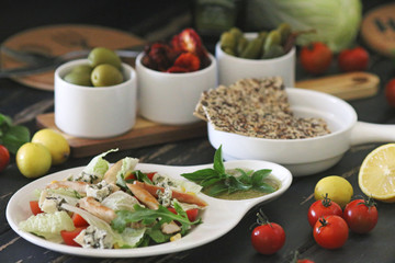Caesar salad served with olives and tomatoes