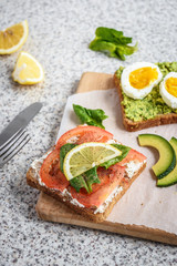 Healthy avocado and egg toasts. Toast, avocado, egg, tomatoes, spinach, cheese Feta, lemon. Organic healthy food. Clean healthy eating