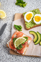 Healthy avocado and egg toasts. Toast, avocado, egg, tomatoes, spinach, cheese Feta, lemon. Organic healthy food. Clean healthy eating