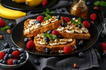 French cinnamon toast with blueberries, raspberries, banana, nuts, hazelnut and honey.