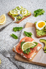 Healthy avocado and egg toasts. Toast, avocado, egg, tomatoes, spinach, cheese Feta, lemon. Organic healthy food. Clean healthy eating
