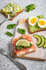 Healthy avocado and egg toasts. Toast, avocado, egg, tomatoes, spinach, cheese Feta, lemon. Organic healthy food. Clean healthy eating