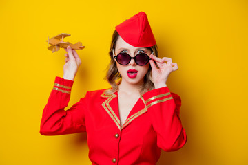 charming vintage stewardess wearing in red uniform with airplane