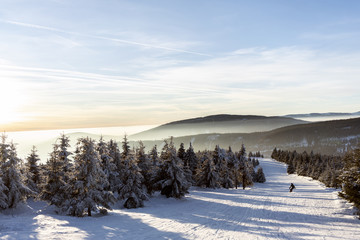 Lonely snowboarder freeriding in beautiful winter scenery during sunset.