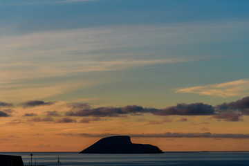 sunrise in azores, view of a small isalnd in front of angra do heroismo during sunrise. azores, portugal