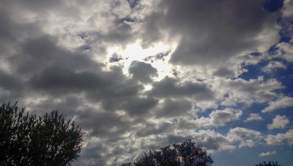 Fototapeta premium Cielo con nube y sol escondido