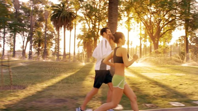 Athlete couple jogging in a park at dawn