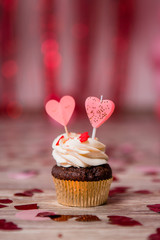 Chocolate cupcake with Valentines heart on the top, over red background with space for the text