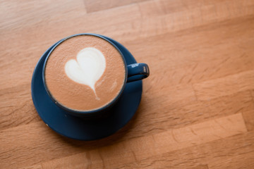 Fototapeta na wymiar cappuccino with milk foam in a heart shape on wooden background.copy spase