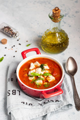 Warm tomato soup with chicken, vegetables and basil. Light concrete background. Copy space. Top view. 