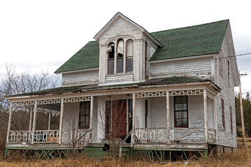 An old, abandoned house. Windows at the top are broken, the paint is peeling, and the front porch...