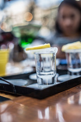 shot glass filled with tequila service with lemon and salt