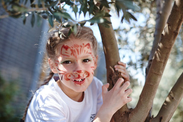 Cute girl with face cat make up on birthday smiling roaring like small tiger