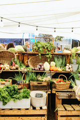 Fototapeta premium Vegetables and fruits on wooden shelf being sold at the Oranjezicht City Farm Market in Cape Town, South Africa
