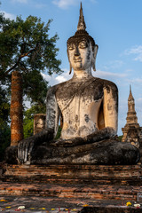 Fototapeta premium Buddha Statue in the morning at wat mahathat in Sukhothai Historical Park, Thailand, one of Thailand's most impressive World Heritage Sites, includes the remains of 21 historical sites. 