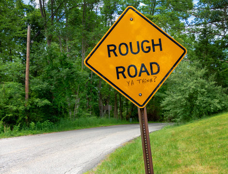 Orange Caution Sign Warning Of Rough Road Ahead