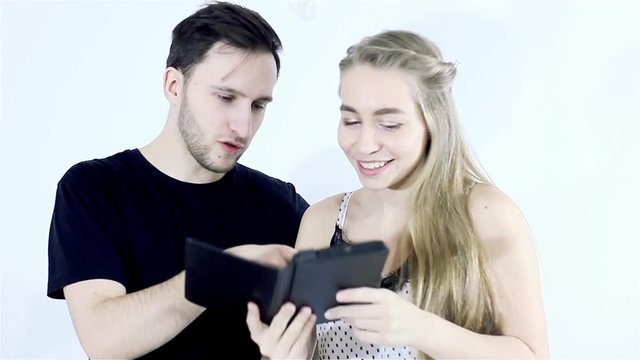 young couple of lovers chooses products on the tablet in the online store.