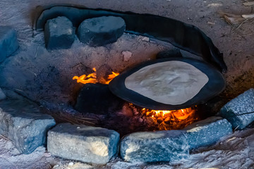 Pita bread cooking on fire in a bedouin dwelling