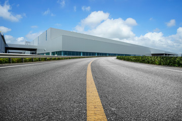 Road asphalt pavement and modern factory warehouse..