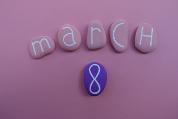 8 March, women day with pink colored stones over pink background