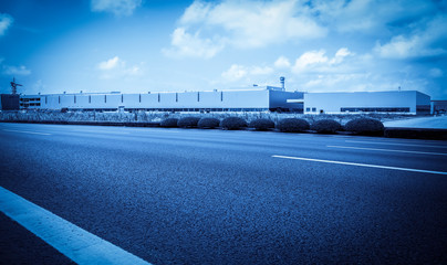 Road asphalt pavement and modern factory warehouse..