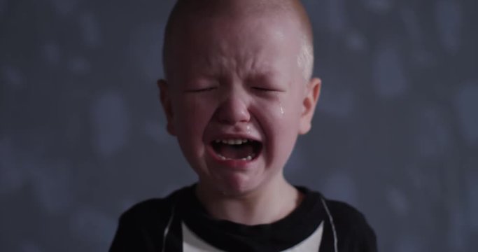 Concept of emotion. Little blond boy suddenly burst into tears. Child cry and can not calm down and confused.