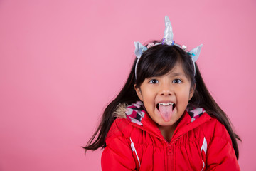 little 8 year old girl showing tongue dressed as unicorn