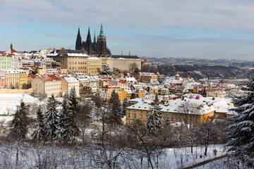 Obraz premium Snowy Prague City with gothic Castle from Hill Petrin in the sunny Day, Czech republic