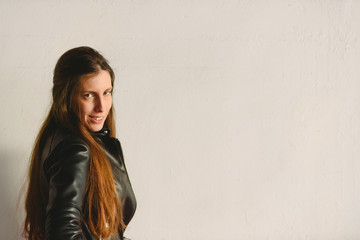 Obraz premium Young millennial woman standing in profile on white and red wall background spoiled with copy space for text, real people looking at camera.
