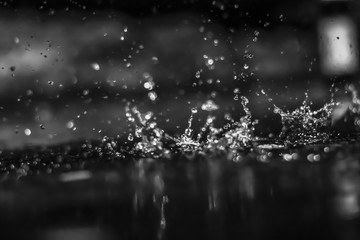 Water drops in the dark outside. Black and white.