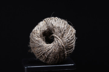 Coil of jute twine on a black background.