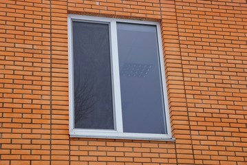 large white window on a brown brick wall of a building