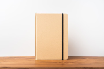 Perspective view of kraft notebook on wood floor
