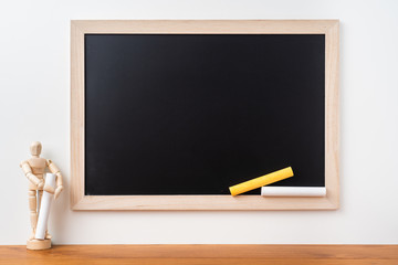 blackboard with wood puppet on teak floor